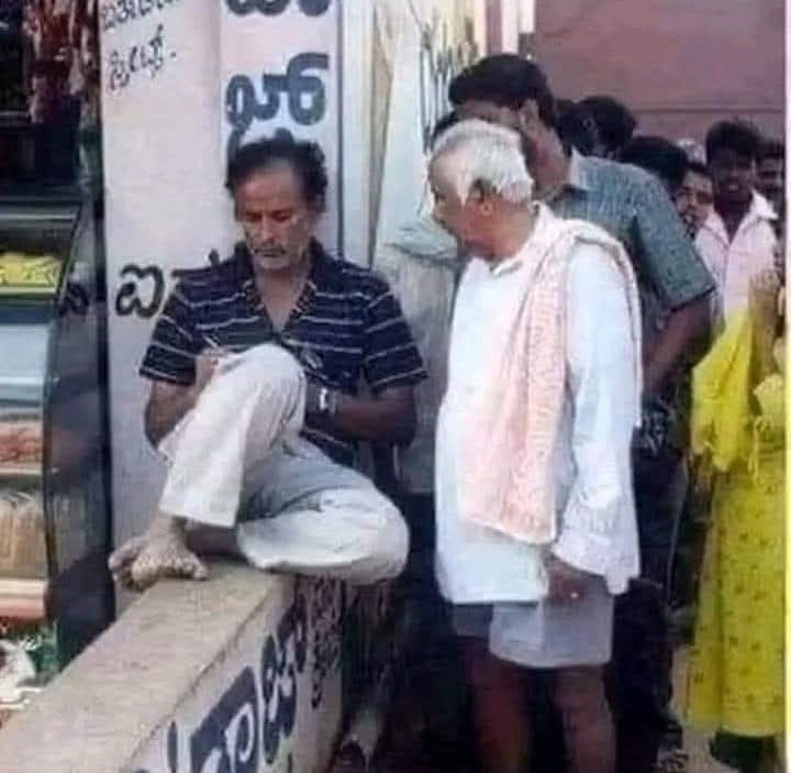 سادہ کپڑوں میں ملبوس ایک شخص ننگے پاؤں دیوار پر بیٹھا، ہاتھ میں 3 روپے کا قلم ل